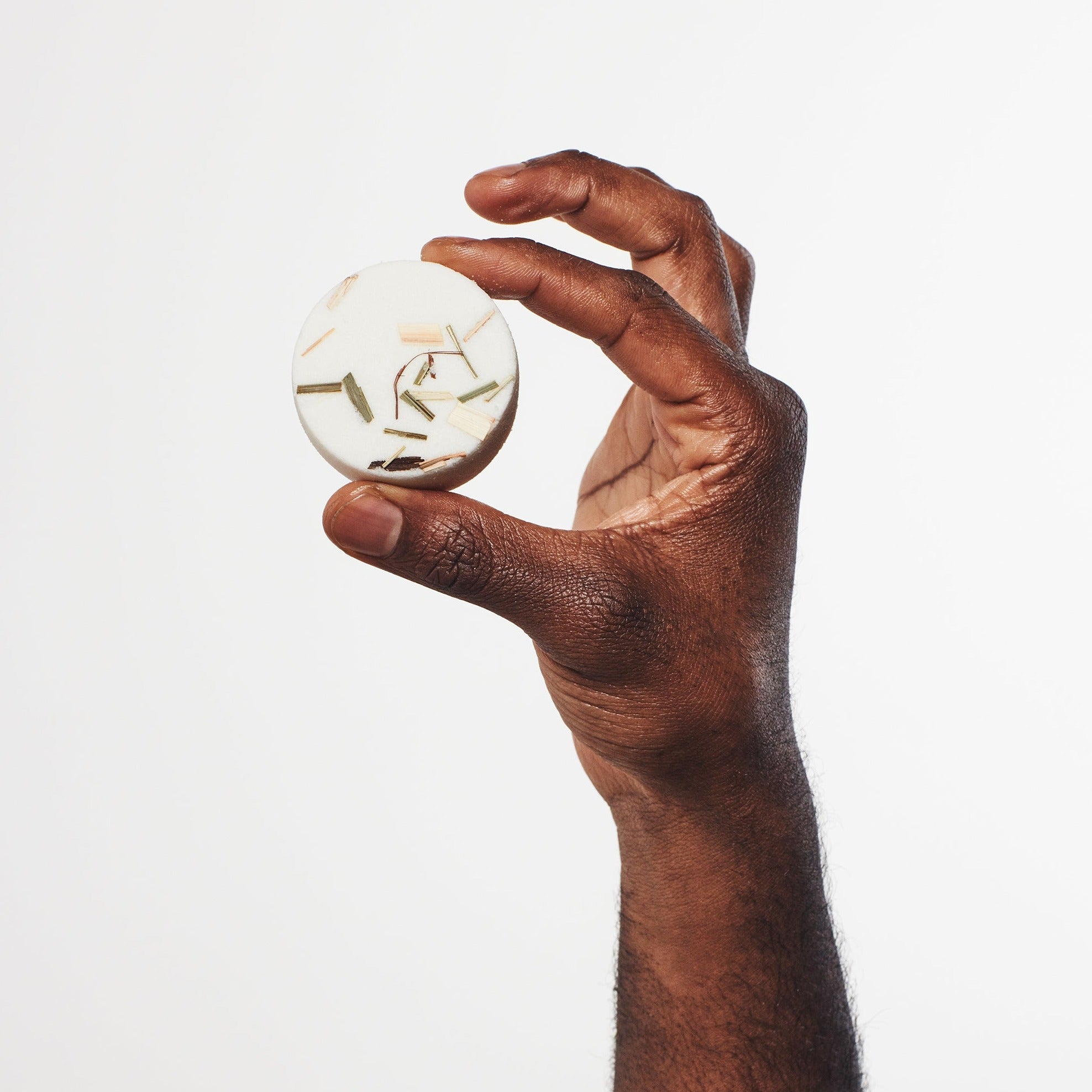 Man holding Lemongrass, Rosemary, and Tea Tree aromatherapy shower steamer for a refreshing and clarifying shower experience.