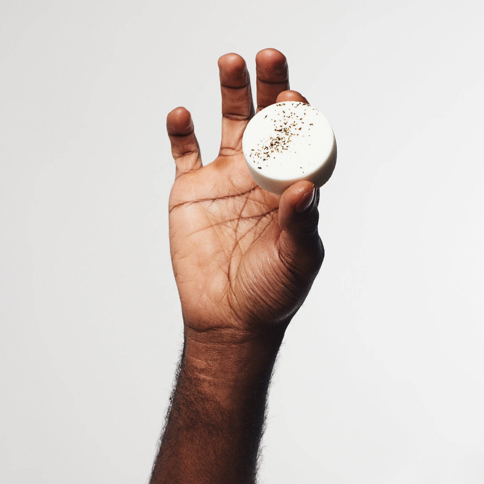 Man holding Eucalyptus, Peppermint, and Lemon aromatherapy shower steamer for refreshing and invigorating shower experience.