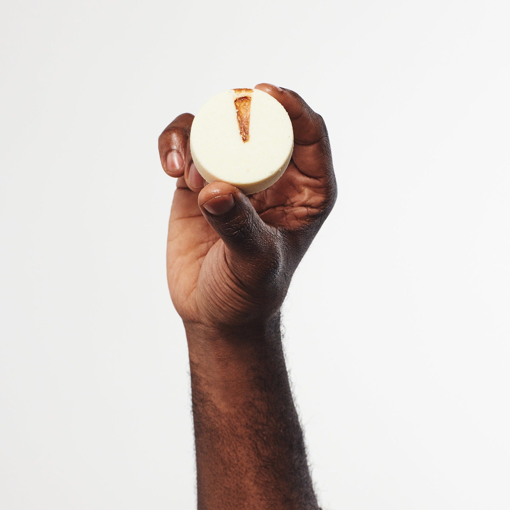 Man holding Orange, Lemon, and Lime aromatherapy shower steamer for an uplifting and energising shower experience.